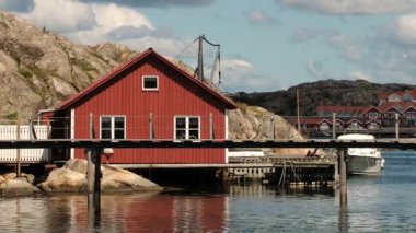 Kırmızı ahşap binalar ve liman Smogen, İsveç kasabasında görünümüne.