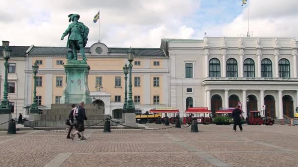 Mensen lopen door de straat voor het monument van de Zweedse koning Gustav Ii Adolf in Göteborg, Zweden. — Stockvideo