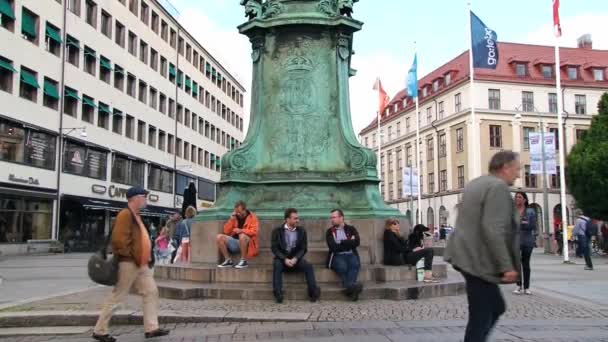 La gente se relaja junto a la estatua ecuestre de bronce y cobre del rey Carlos IX en Gotemburgo, Suecia . — Vídeos de Stock