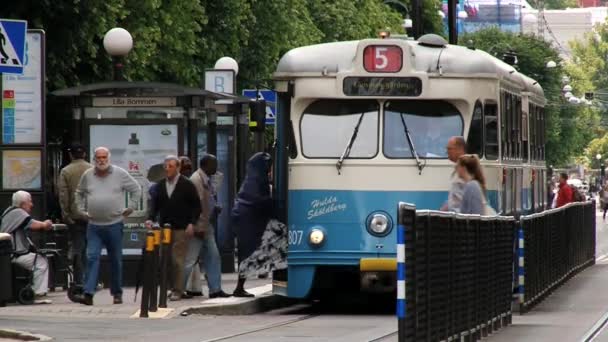 Люди въехали в трамвай на остановке общественного транспорта в шведском Гетеборге . — стоковое видео