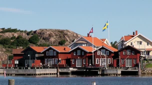 Pohled do červených dřevěných budov malé rybářské městečko Fjallbacka, Švédsko. — Stock video