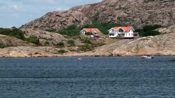 Pohled do bílých dřevěných staveb a skalnaté pobřeží ve městě Smogen, Švédsko. — Stock video