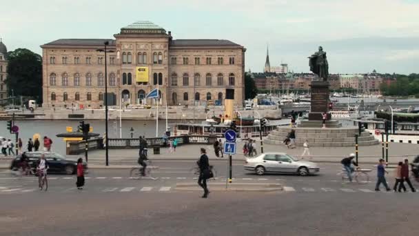Utcára néző, elhaladó autók, és a király Gustav szobor a háttérben, Stockholm, Svédország. — Stock videók