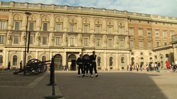 People serving as royal guards walk by the square in front of the Royal palace building in Stockholm, Sweden. — Stock Video