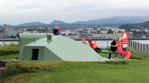 Grupo de crianças com uma peça de professor no canhão alemão WW2 na fortaleza da ilha Munkholmen em Trondheim, Noruega . — Vídeo de Stock