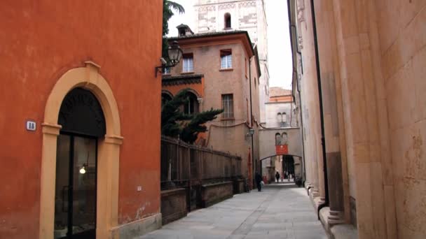 As pessoas caminham pela rua com o campanário românico Ghirlandina da Catedral de Modena ao fundo em Modena, Itália . — Vídeo de Stock