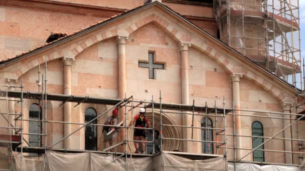 Люди роблять реставраційні роботи церковного фасаду в Пьяцца Гранде, Модена. — стокове відео