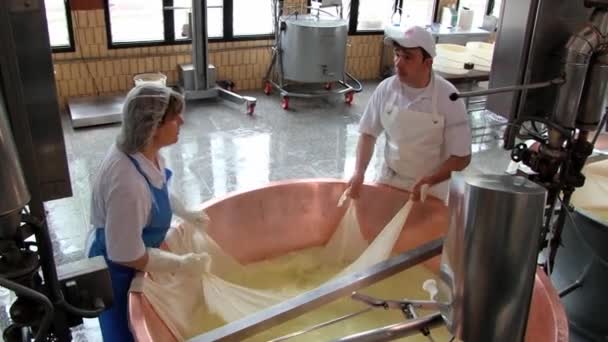 Lidé produkují sýr parmezán v továrně v Modena, Itálie.