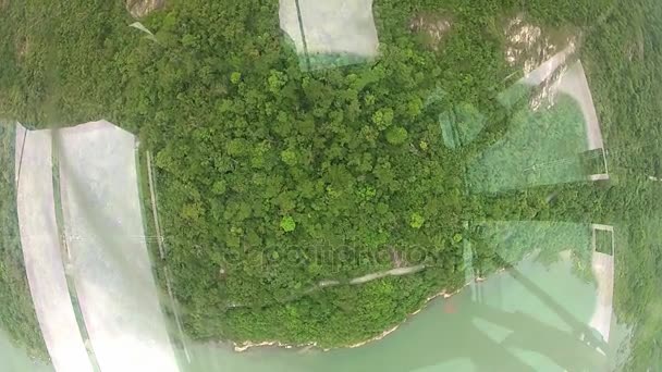 Vue vers le bas à travers le plancher de verre de la cabine du téléphérique Ngong Ping 360 dans l'île de Lantau, Hong Kong . — Video