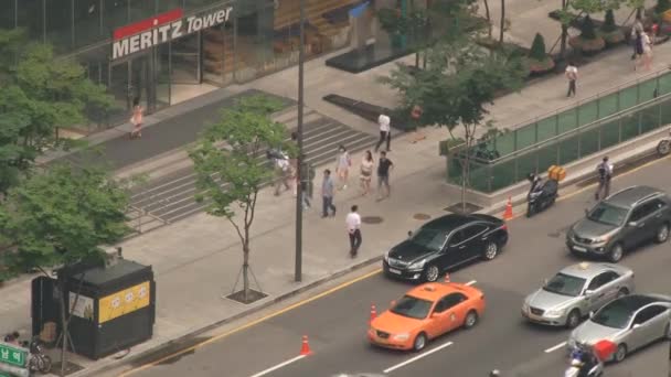 Vista desde arriba hacia el tráfico y la gente caminando en la calle del distrito de Gangnam en Seúl, Corea . — Vídeo de stock