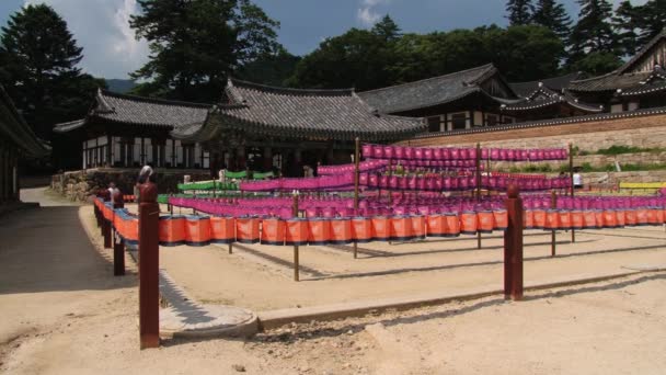 Pelgrims lopen door de tuin in Moenjodaro tempel in Kerak, Zuid-Korea. — Stockvideo