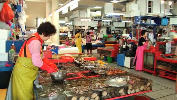 La gente vende pescado y marisco en el mercado de pescado en Busan, Corea . — Vídeo de stock