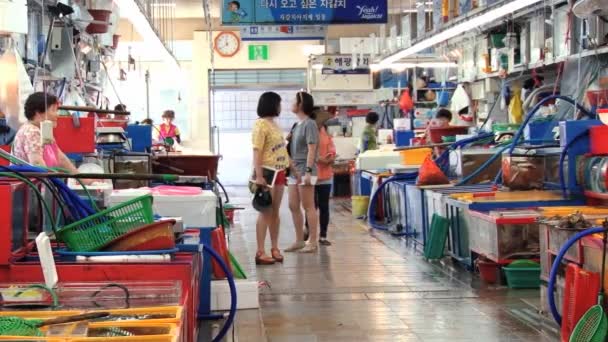 Mensen verkopen vis en zeevruchten op de vismarkt in Busan, Zuid-Korea. — Stockvideo