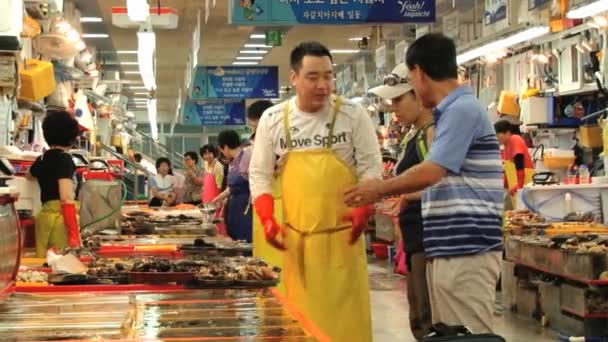 Menschen verkaufen Fisch und Meeresfrüchte auf dem Fischmarkt in Busan, Korea. — Stockvideo