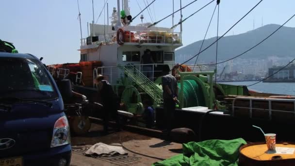 Personer lasta fryst fisk från fiskebåten på havet hamnen i Busan, Korea. — Stockvideo