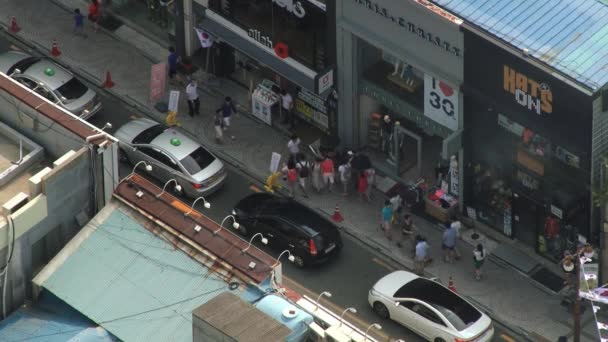 As pessoas passam pela rua em Busan, na Coreia. Vista de cima . — Vídeo de Stock