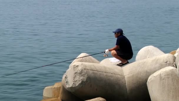 Homem faz pesca com barcos que partem do porto durante festival de Hansan no fundo em Tongyeong, Coréia . — Vídeo de Stock