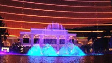 Makao, Çin için ön planda dans çeşmeler ile Wynn hotel cephe görüntülemek.