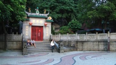 Makao, Çin A-Ma Budist tapınağı giriş kapısında insanlar oturup.