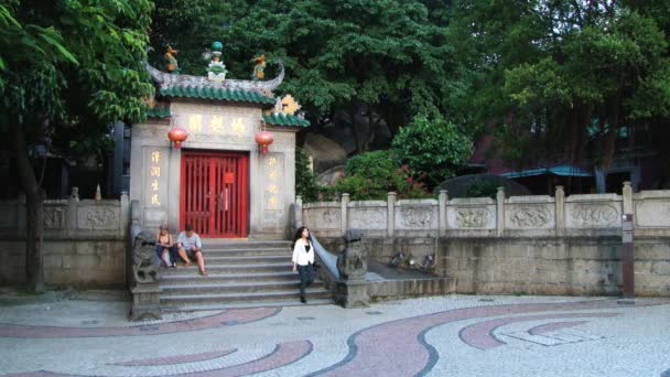 Lidé sedí u vstupní brány do A-Ma buddhistický chrám v Macau, Čína. — Stock video