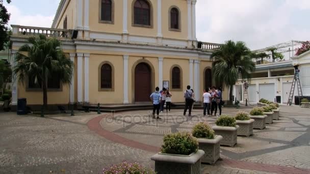 La gente si trova di fronte all'edificio della chiesa del villaggio Taipa a Macao, in Cina . — Video Stock