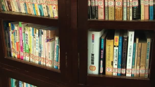 Vue sur l'étagère à livres avec des livres en chinois dans une bibliothèque publique à Macao, Chine . — Video