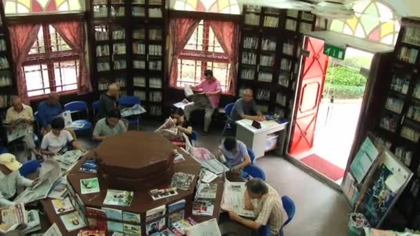 La gente lee periódicos en una biblioteca pública en Macao, China. Vista desde arriba . — Vídeo de stock