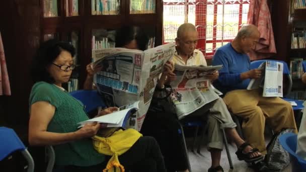 Folk läser dagstidningar i ett offentligt bibliotek i Macau, Kina. — Stockvideo