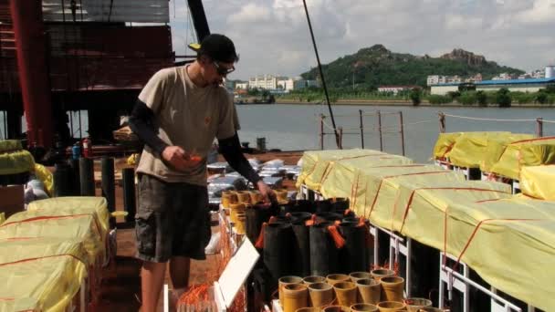 Ο άνθρωπος προετοιμάζει εξοπλισμού στην πλωτή εξέδρα για την εμφάνιση του διάσημου πυροτέχνημα και φεστιβάλ στο Μακάου, Κίνα. — Αρχείο Βίντεο