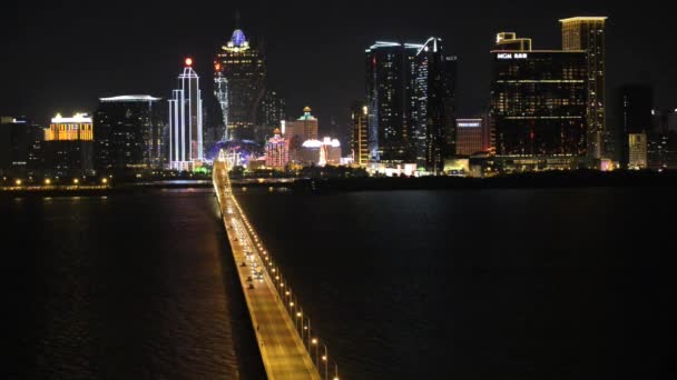 Veduta delle auto che passano vicino al ponte con lo skyline notturno della città di Macao, Cina . — Video Stock