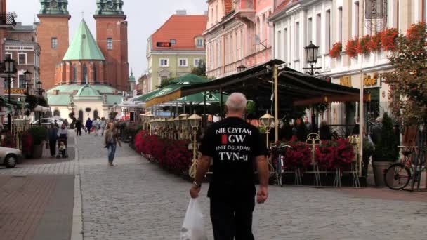 Mensen lopen door de straat in de historische stad van Gniezno, Polen. — Stockvideo