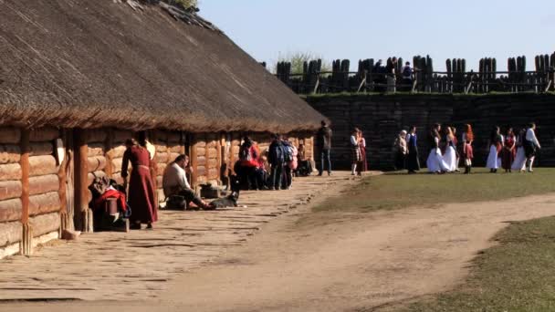 Biskupin、ポーランドの鉄器時代の要塞化された集落の人々 の訪問レプリカ. — ストック動画