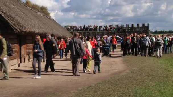 Mensen bezoeken replica van de IJzertijd versterkte nederzetting in Biskupin, Polen. — Stockvideo