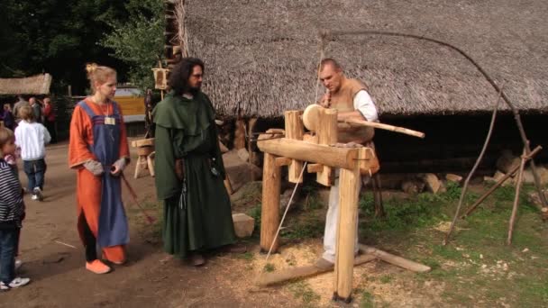 El hombre demuestra el trabajo sobre el torno de torneado tradicional primitivo en Biskupin, Polonia . — Vídeo de stock