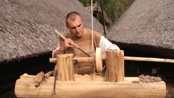 Ember mutatja be a munkáját a primitív hagyományos eszterga eszterga Biskupin, Lengyelország. — Stock videók