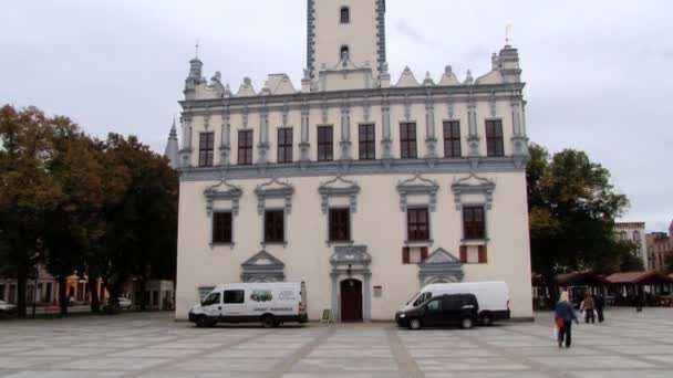 People walk by the square in front of the town hall building in Helmno, Poland. — Stock Video