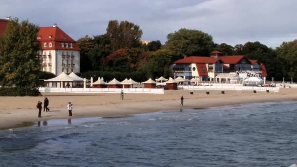 People walk by the seaside in Sopot, Poland. — Stock Video