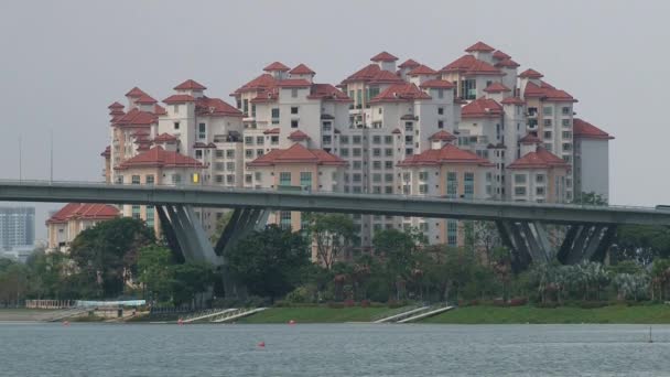 Autos passieren die Brücke mit den modernen Wohngebäuden im Hintergrund in singapore, singapore. — Stockvideo