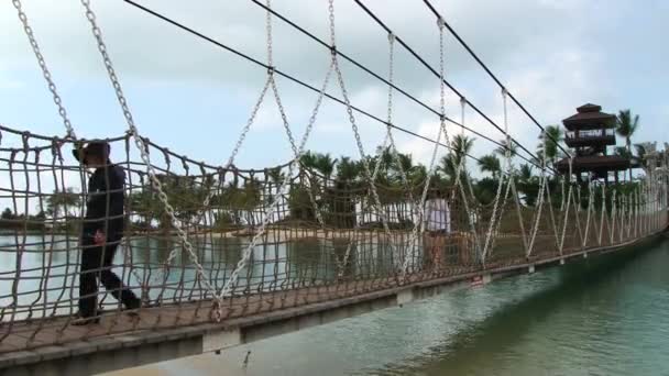 La gente camina por el puente colgante en la playa de Palawan en la isla Sentosa, Singapur . — Vídeos de Stock