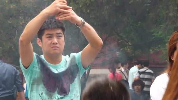 La gente reza y quema incienso en el templo Yonghe en Beijing, China . — Vídeos de Stock