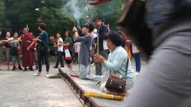 Mensen bidden en het branden van wierook in de Yonghetempel in Peking, China. — Stockvideo