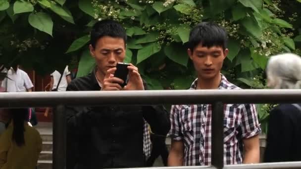 사람들이 중국 베이징에서에서 영화 사원에서 사진 카메라와 휴대 전화 사진 확인. — 비디오