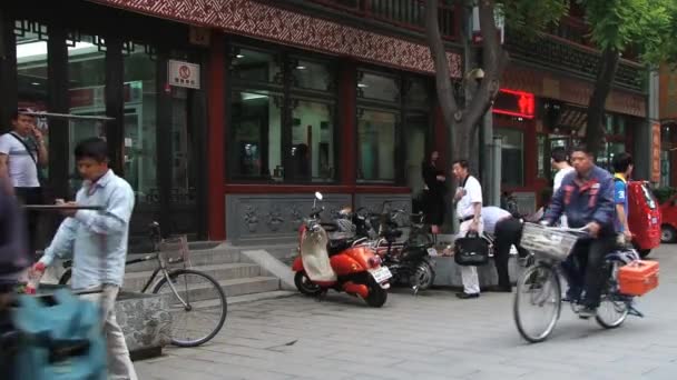 Menschen fahren mit Fahrrädern durch eine Straße in Peking, China. — Stockvideo