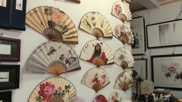 Άνθρωποι το χρωματίζουν παραδοσιακά οπαδούς σε ένα εργαστήριο στο Πεκίνο, Κίνα. — Αρχείο Βίντεο