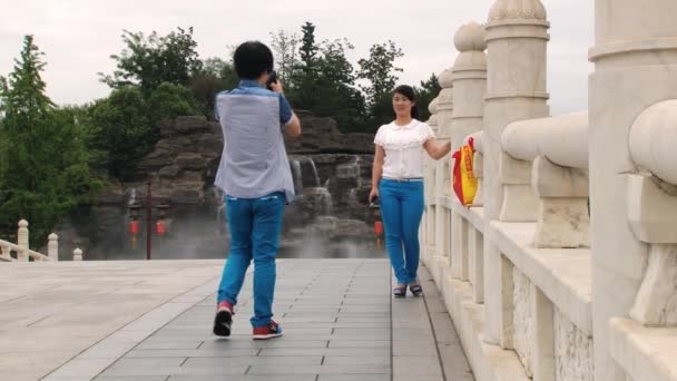 Китайская пара делает фотографии путешествий со смартфонами в саду Datang Furong в Сиань, Китай . — стоковое видео