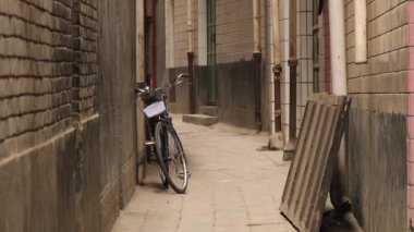 İnsanlar caddenin kenarındaki bir bisiklet ile tarafından arka planda Xian, China, sokak geçer.