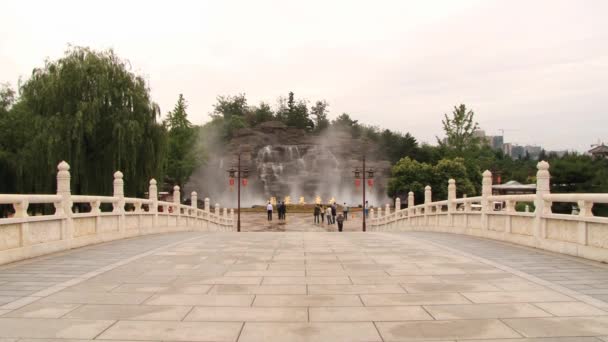 Люди посещают водопад в саду Датан Фужун в Сиань, Китай . — стоковое видео
