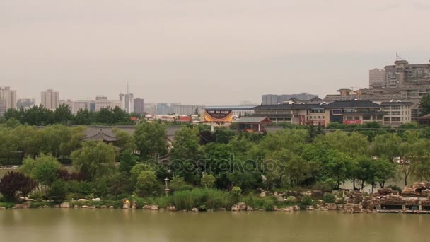 西安、中国の大唐芙蓉園から水を渡って都市の近代住宅を見る. — ストック動画