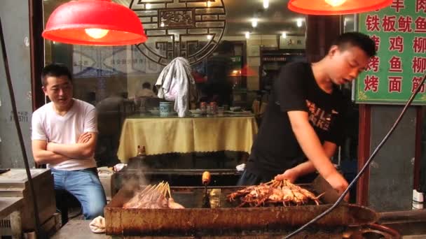 People cook at a street restaurant in Xian, China. — Stock Video