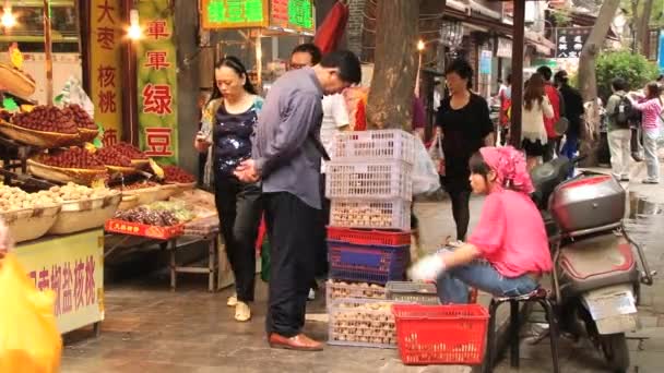 Menschen gehen an einem Street Food Markt in Xian, China vorbei. — Stockvideo